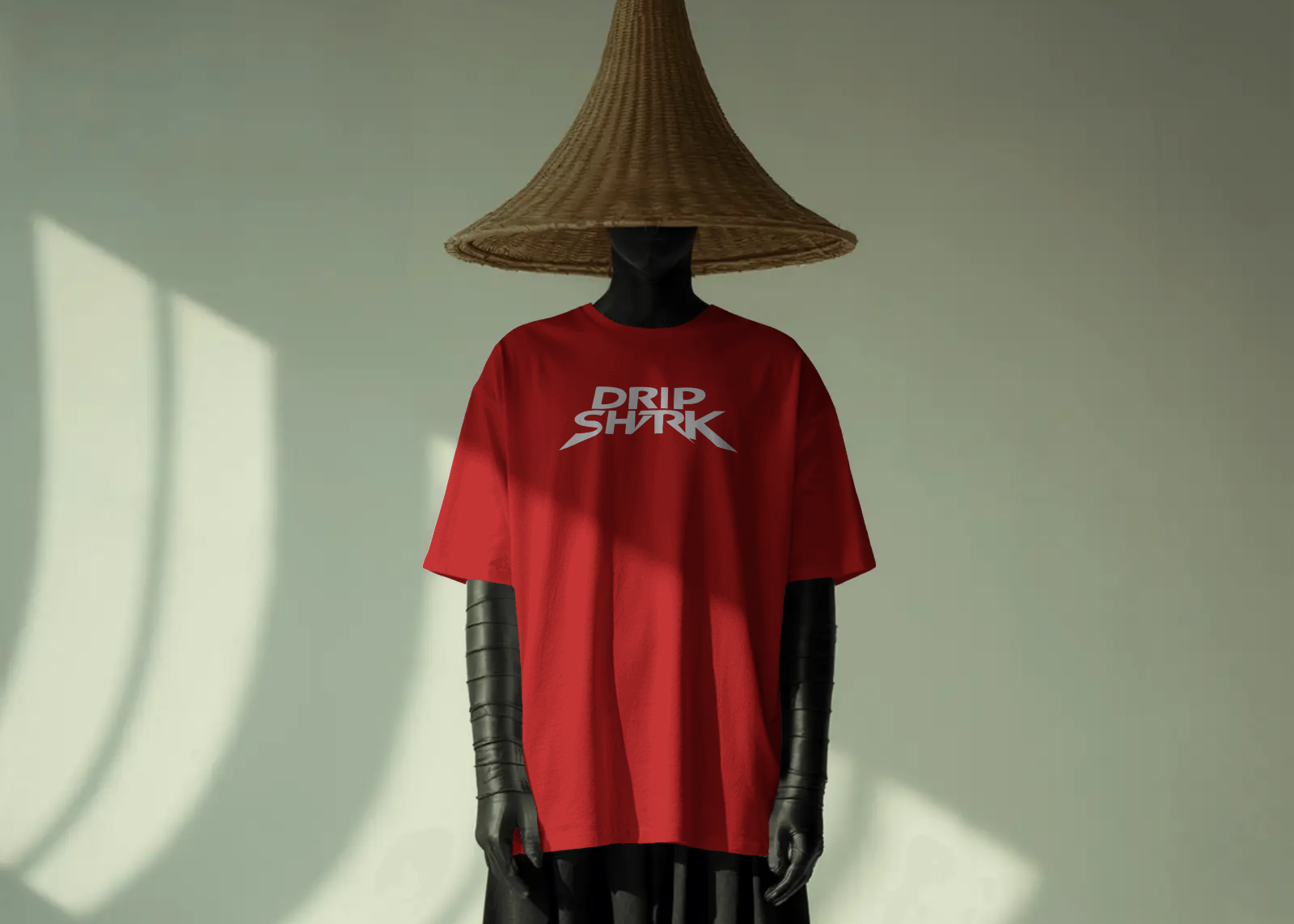 Person wearing a red 'Dad Shark' t-shirt and black pants with a straw hat in a minimalistic setting.